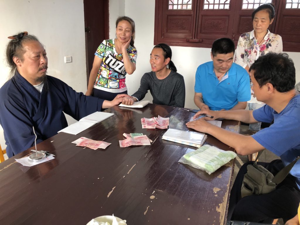 a photo of a Daoist priest treating people at a clinic