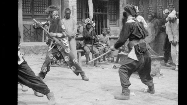 Staff fighters in 1924 performing a morality play about a just emperor fighting off bandits